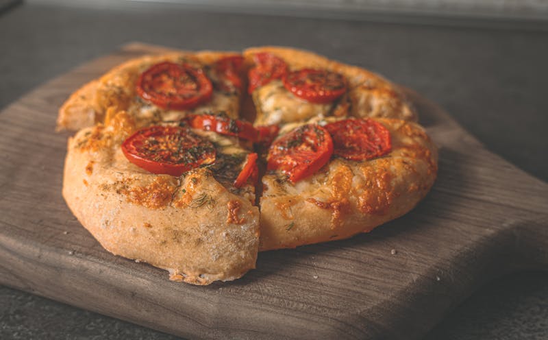 Pizza being baked in a stone deck oven with glowing heat